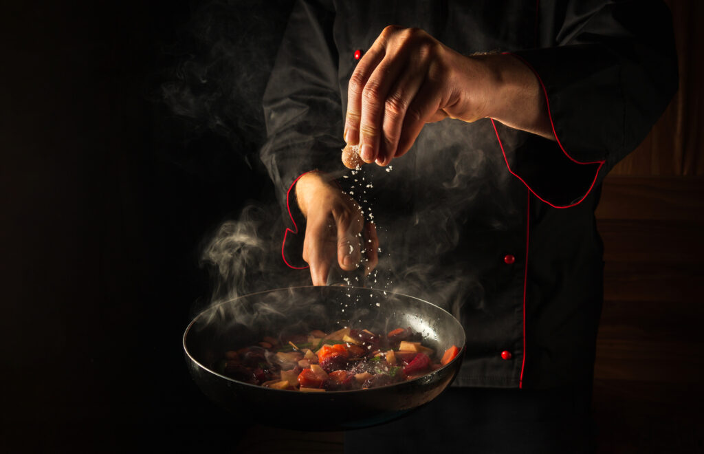 chef-adds-salt-steaming-hot-pan