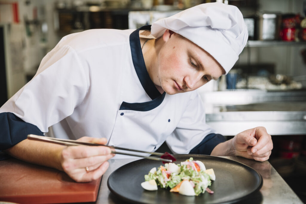 cook-putting-vegetable-plate-with-salad